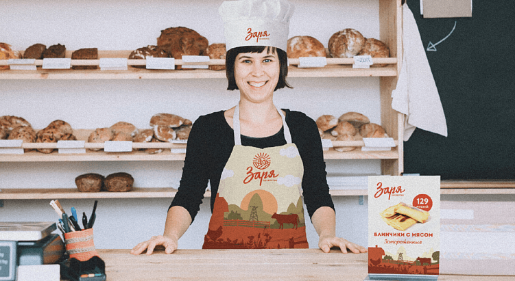 Продавец в фирменной форме хозяйства «Заря» с элементами ретро-стиля на фоне прилавка с хлебом — визуал бренда, подчеркивающий преемственность и тепло ручного труда.