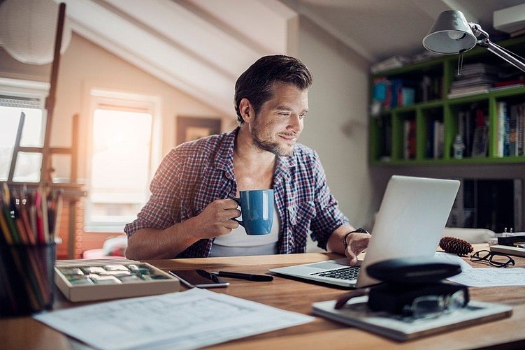 фрилансер за ноутбуком с чашкой кофе