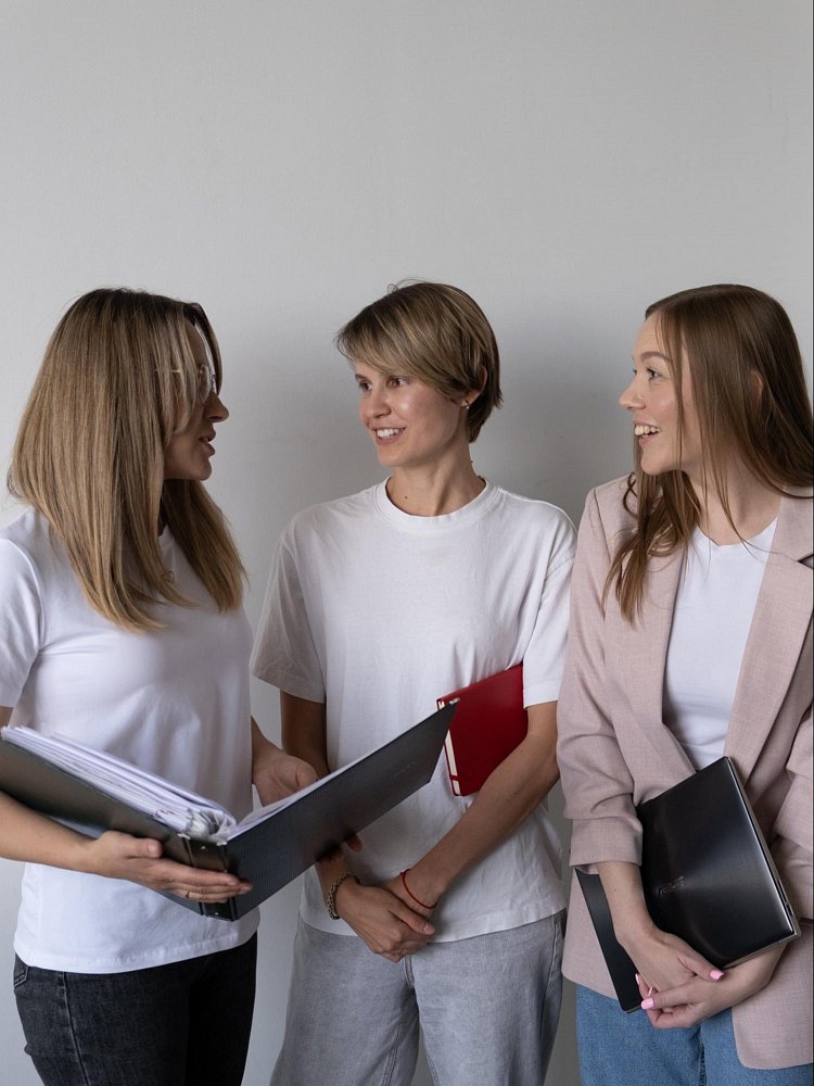 По центру ‒ Ольга, руководитель отдела SEO, обсуждает стратегию развития с коллегами, Аленой и Дарьей из отдела аккаунтинга.