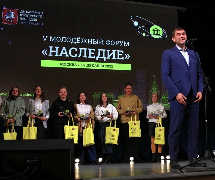 Лауреаты форума на сцене с наградными комплектами в брендированных шопперах и памятными плакетками в руках